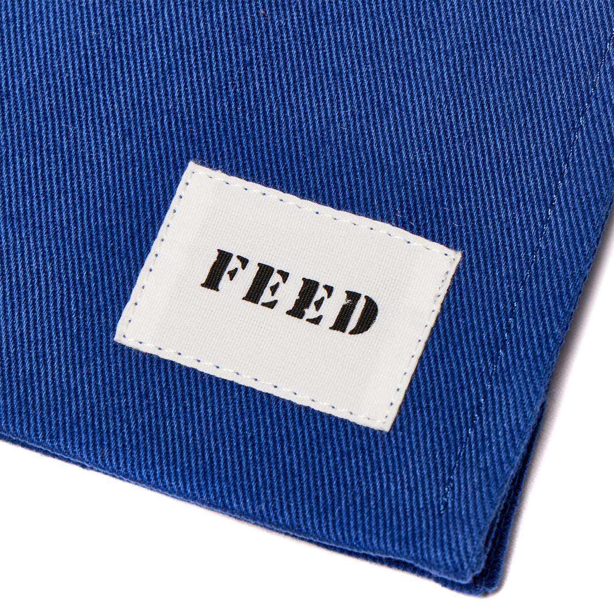 Cobalt | Detail shot of FEED logo on cobalt blue Book Bag