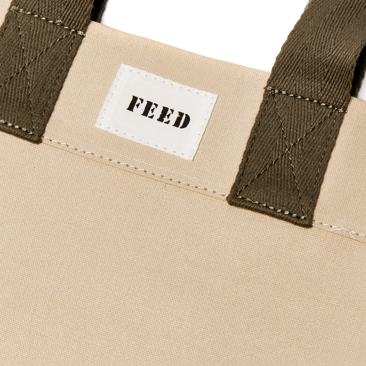 Sand | Logo detail of sand FEED 10 tote bag with FEED the Children of the World text.
