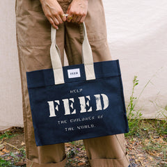 Black | Lifestyle of black FEED 10 tote bag with FEED the Children of the World text.