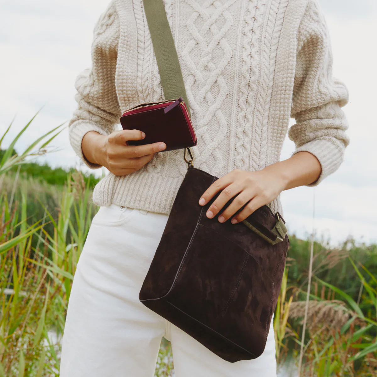 Suede / Burgundy | woman holding wallet and bucket bag